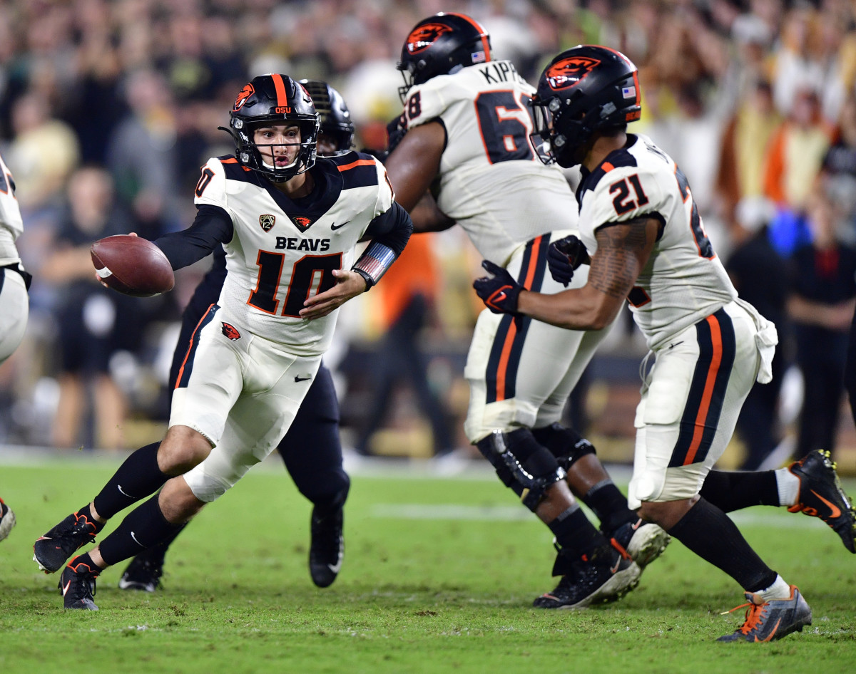 Oregon State quarterback Chance Nolan (10) hands the ball off to running back Trey Lowe (21).